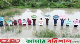 টেকসই বেড়িবাঁধের দাবিতে জোয়ারের পানিতে দাঁড়িয়ে অভিনব প্রতিবাদ